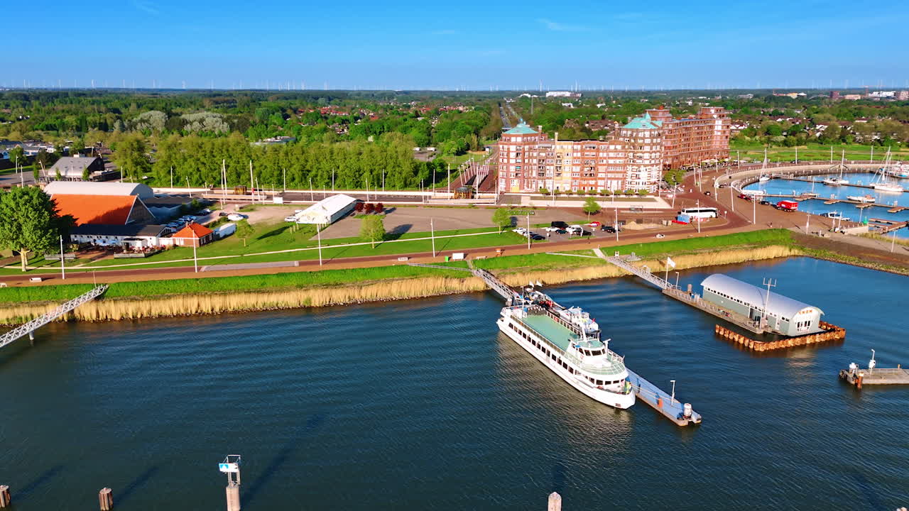 Flight along the shore of Lelystad, the Netherlands. Approaching the port of the city with beautiful buildings on the waterfront.