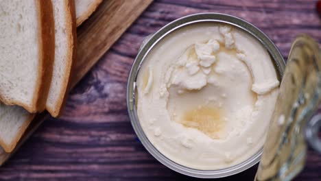 open can of condensed cream with bread