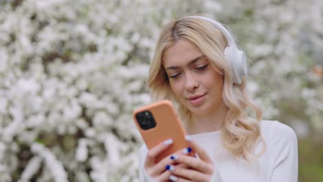 woman listening to music in a spring park