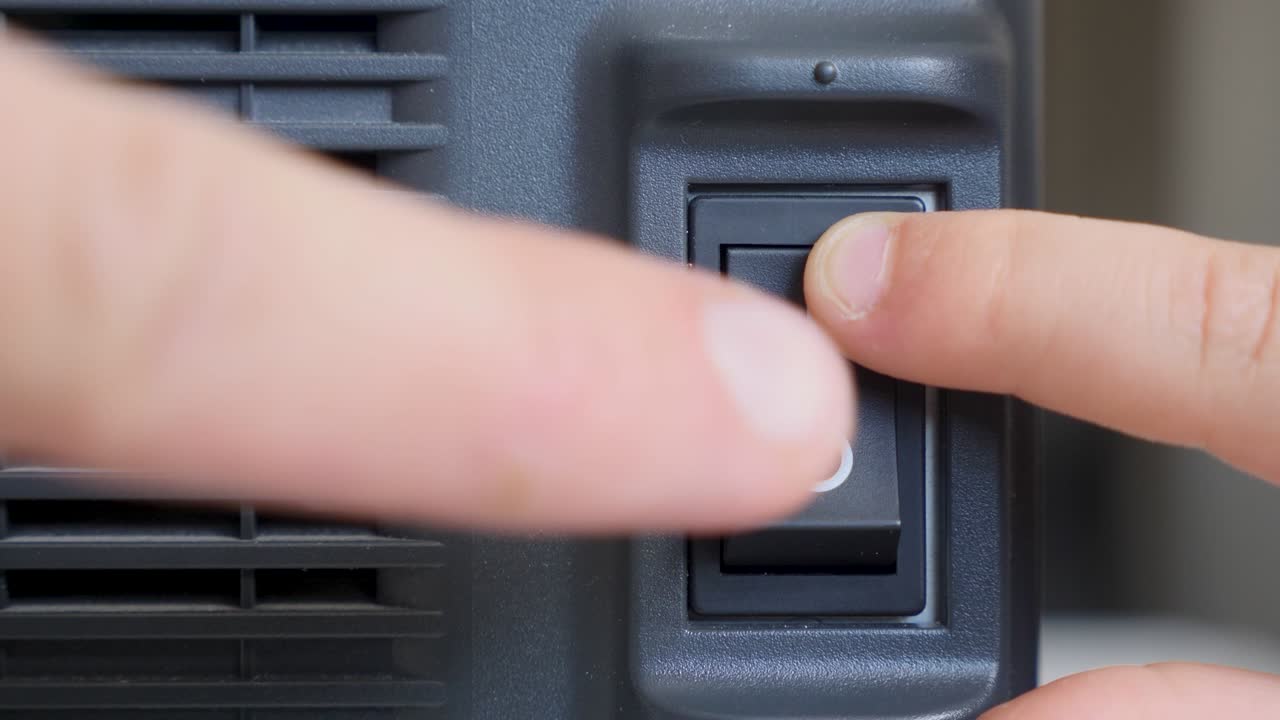 dos dedos, un adulto y un niño, presiona un botón de interruptor negro
