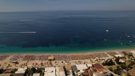 Strand-Voller-Sonnenschirme-In-Der-Nähe-Des-Schönen-Meeres,-Sonnenbaden,-Schwimmen-Und-Segeln-Im-Sommerurlaub