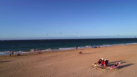 Dröhnen-Durch-Palmen-An-Meeresstränden,-Während-Kiteboarder-Den-Sonnenuntergang-Genießen