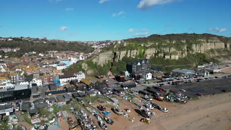 aerial drone shot of hastings uk, camera flying over the stade beach, fishing boats and high street, towards the east hill cliff railway