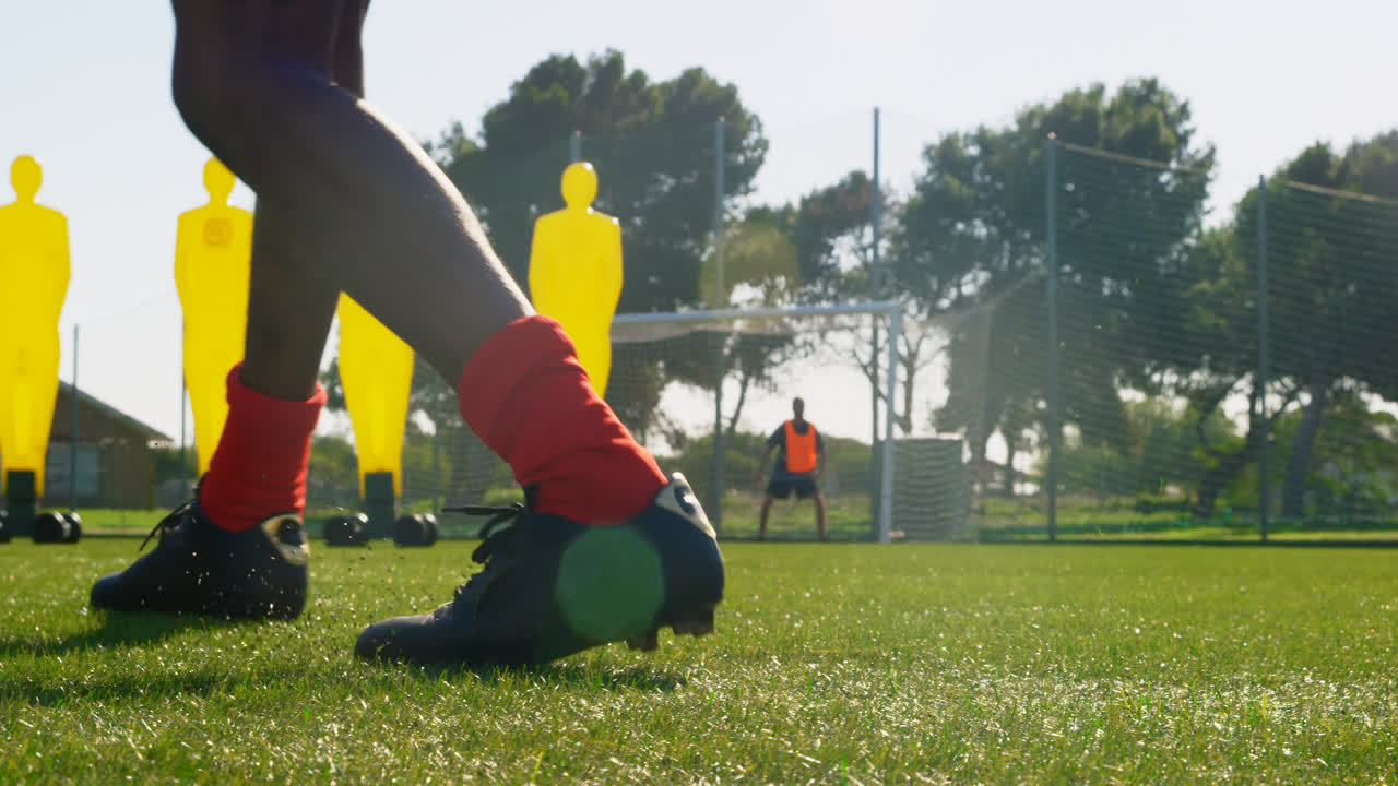 골포스트 4k 쪽으로 공을  ⁇ 고 있는 축구 선수