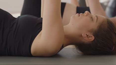 yoga class healthy pregnant woman practicing stretches laying on exercise mat enjoying group physical fitness workout in studio