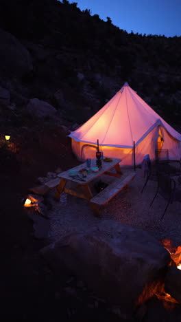 vertical 4k, young woman going out from yurt tent at night, lights in desert landscape