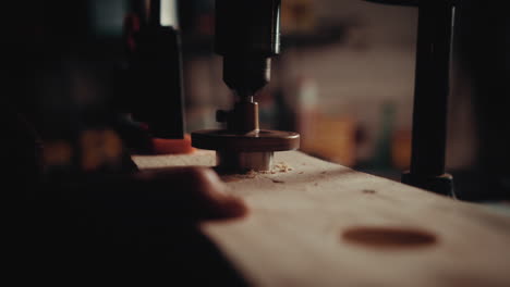 a slow motion of a carpenter drilling wood with a drill on the hard surface