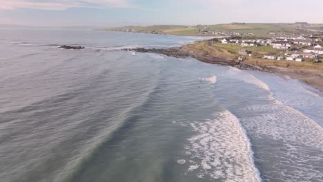 some surfers tasting frozen winter waves on irish shores in slow motion aerial