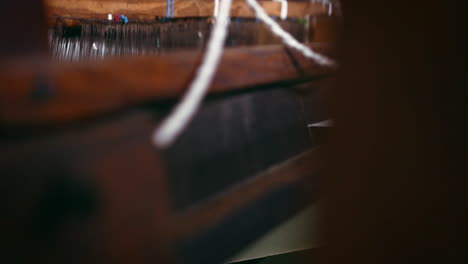 an-unrecognizable-man-operating-a-treadle-loom
