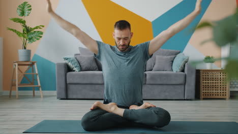 man practicing yoga in his living room