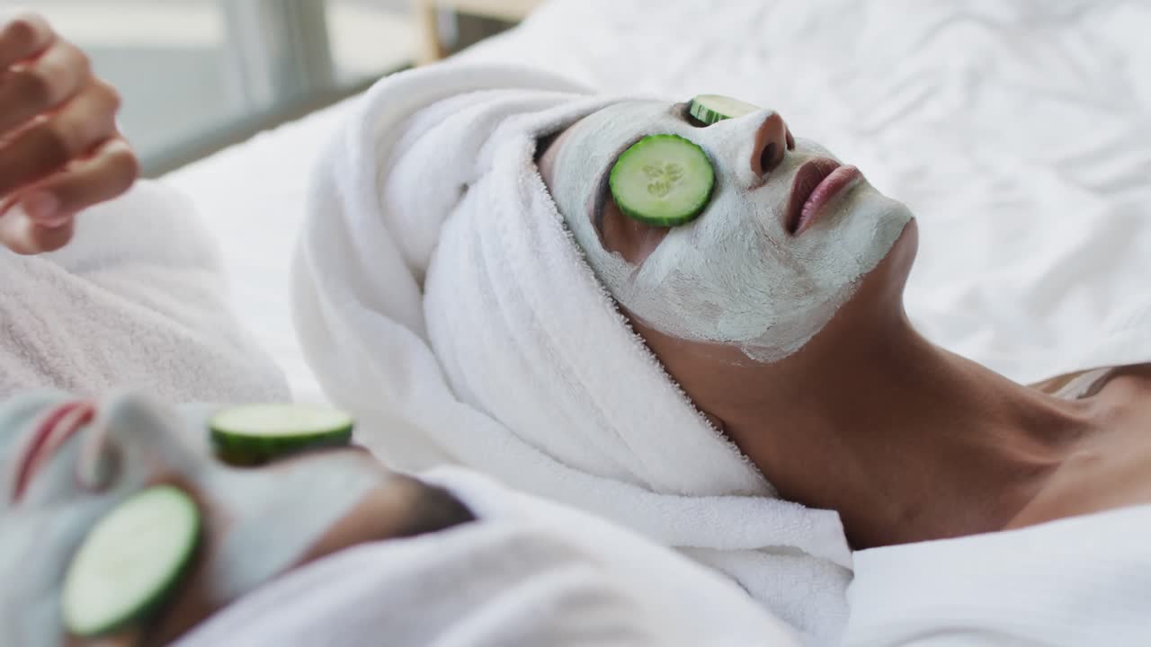 Video di diverse amiche rilassate che si idratano con maschere viso e cetrioli
