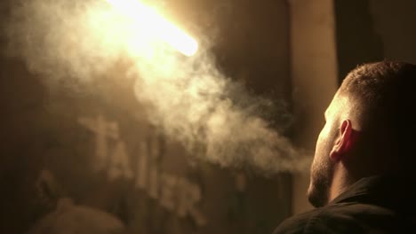 person smoking and exhaling cigarette smoke from his mouth in front of light