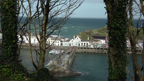 Hermosas-Casas-Junto-Al-Mar-Con-Autos-Estacionados-A-Lo-Largo-Del-Camino-De-Hormigón-En-El-Puerto-De-Ilfracombe,-Ilfracombe,-Inglaterra---Disparo-En-ángulo-Alto