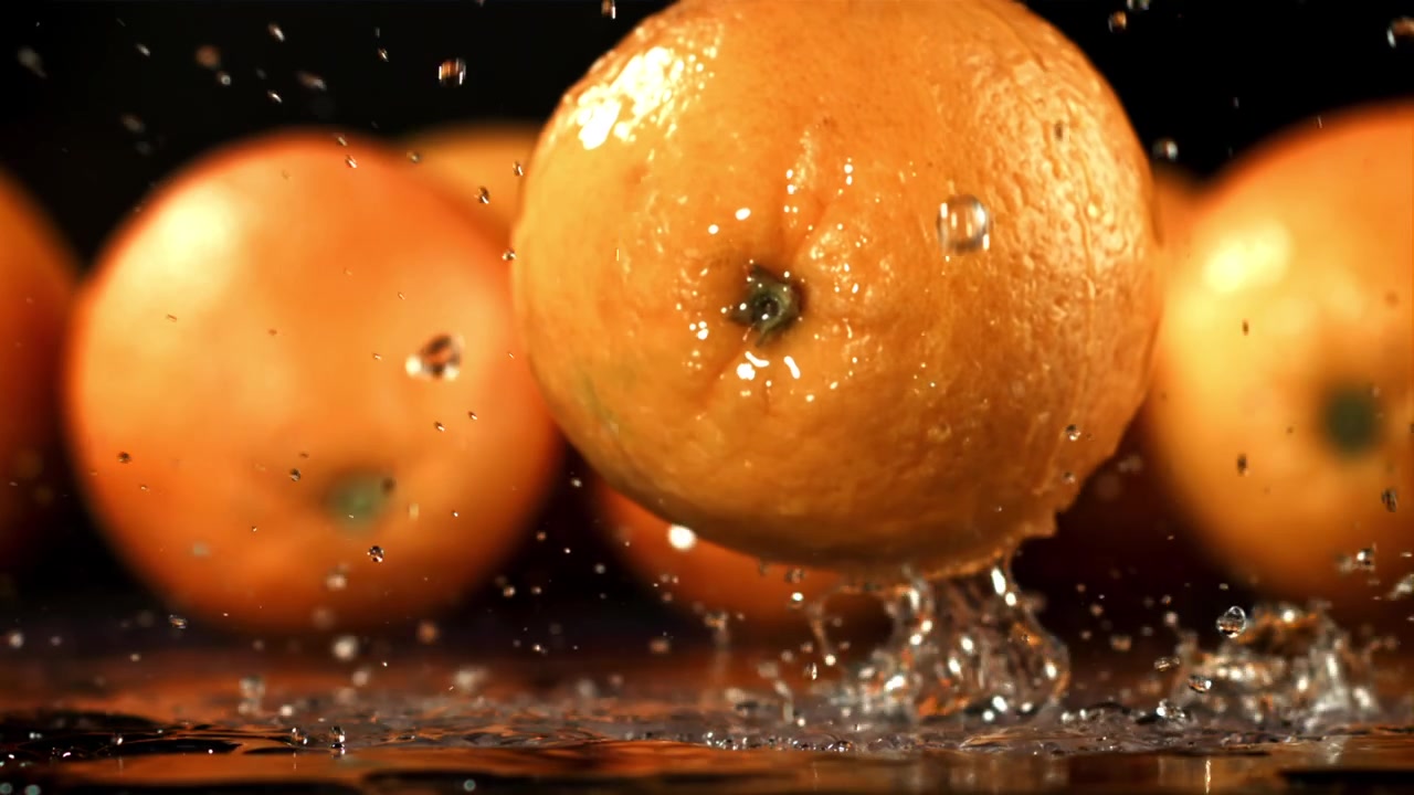 Arancia fresca che cade nell'acqua al rallentatore
