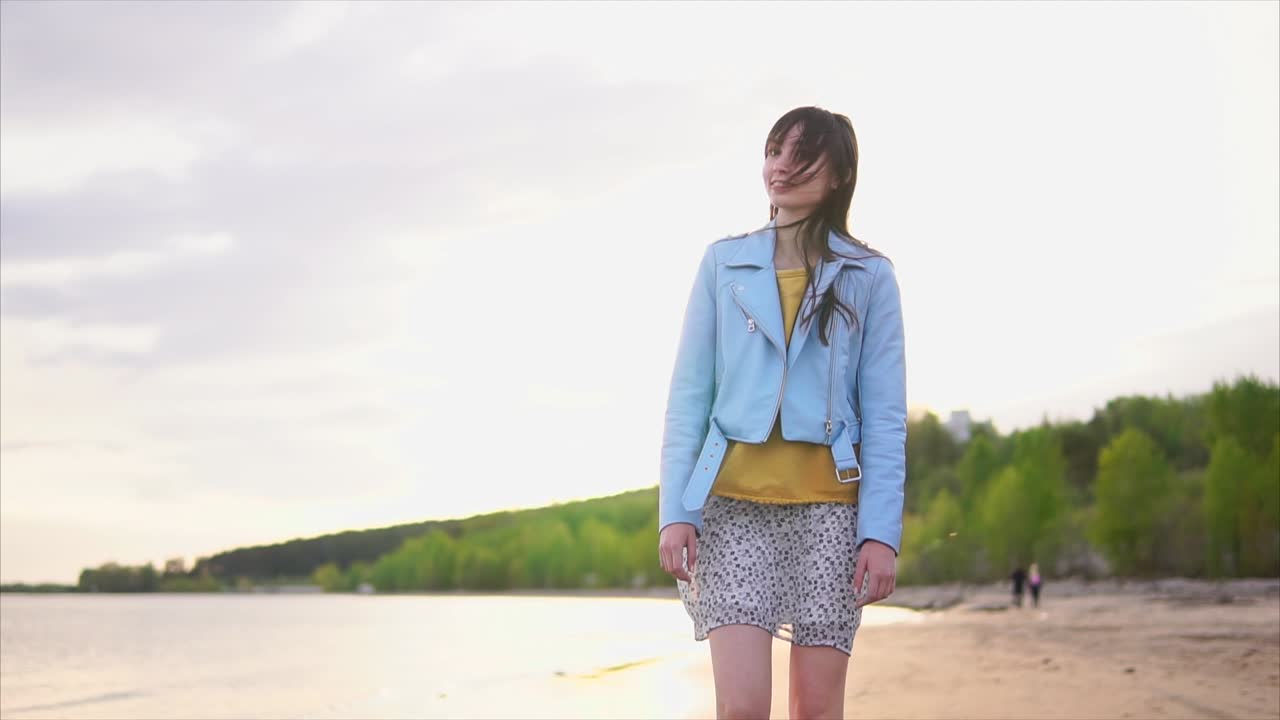 Teenage Girl Walking on the Beach at Sunset