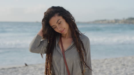 mujer joven hermosa sonriendo corriendo mano a través del cabello disfrutando de un cálido día de verano en la playa mujer de raza mixta en la orilla del océano relajándose