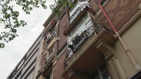 Edificio-Parisino-Con-Ventanas-De-Proa-Decoradas-Con-Plantas-Ornamentales-En-Port-Royal-Boulevard,-Distrito-5-De-París-En-Francia