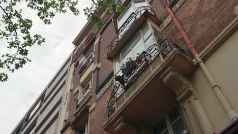 edificio parisino con ventanas de proa decoradas con plantas ornamentales en port royal boulevard, distrito 5 de parís en francia