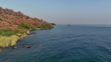 pequeño barco de pesca cerca de la costa de la isla de nankoma, parque nacional del lago malawi, malawi.