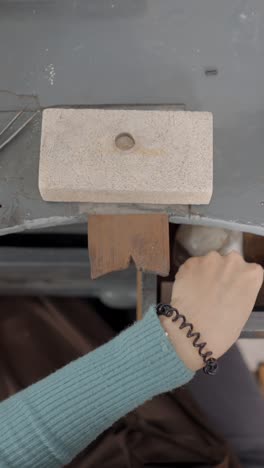 close-up of hands crafting jewelry with tools on a workbench