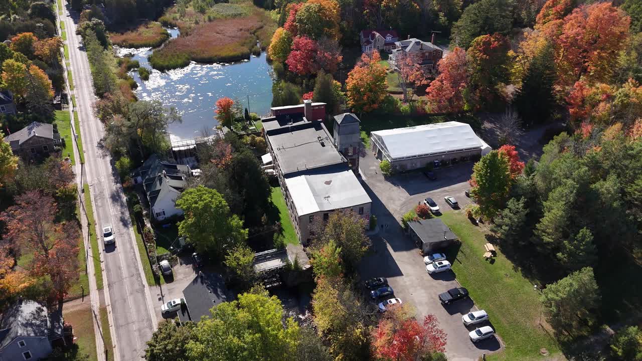 Rotating aerial of The Alton Mill Arts Centre in Alton, Caledon, Ontario, Canada, featuring art studios, galleries, and cultural attractions, during the fall season
