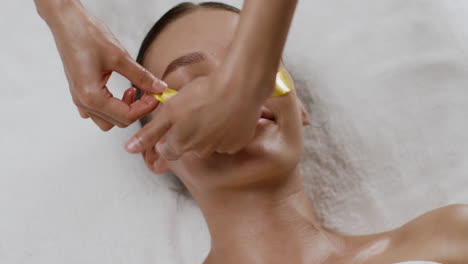 woman getting a facial treatment with gold mask
