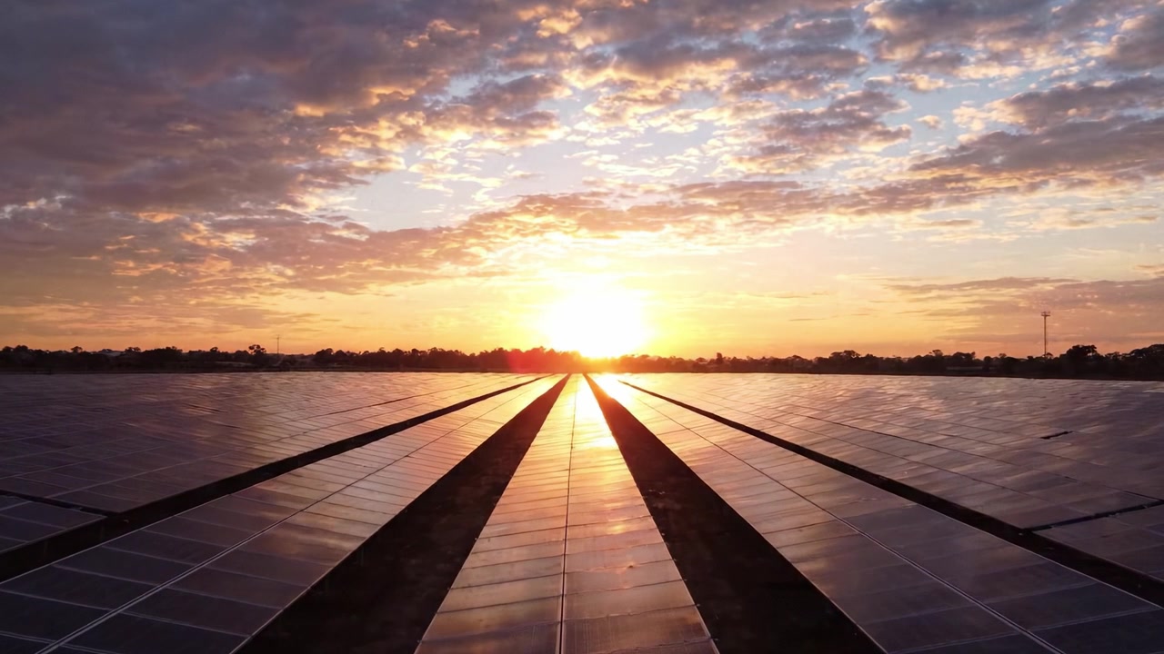 Fængslende Solopgang Over Solpaneler: En Betagende Udsigt over Vedvarende Energis Industrielle Landskab og Naturens Skønhed i Harmoni