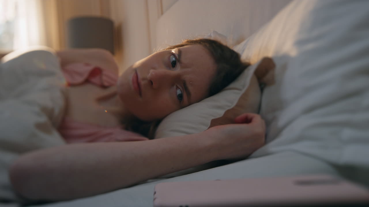 niña somnolienta apagando el despertador en primer plano. adolescente molesto despertando temprano