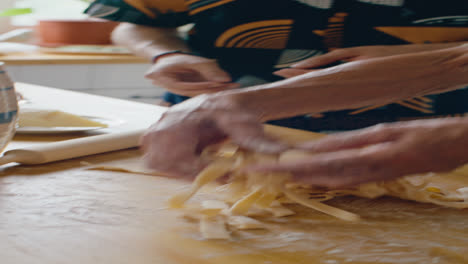 elderly grandmother explaining to grandson how to cook homemade pasta