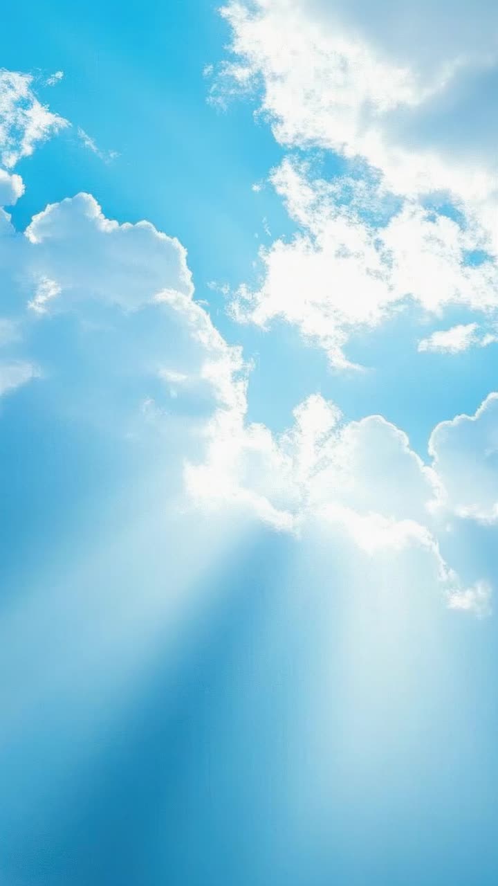 A serene video scene of sunlit clouds against a bright blue sky, captured from a low angle
