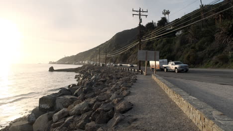 Largos-Recorridos-Recreativos-Con-Tráfico-Fluido-En-El-Borde-De-Una-Carretera-Angosta,-Al-Lado-De-La-Playa-Big-Rock-Malibu