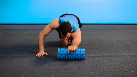 a hand held shot of a guy using a massage roller with only his bodyweight