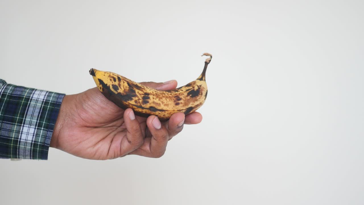 plátano maduro en la mano