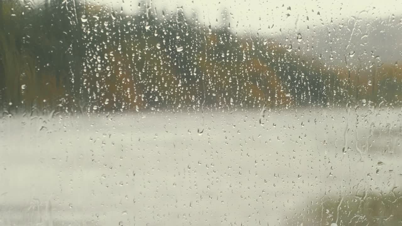 Raindrops rolling down window during stormy weather