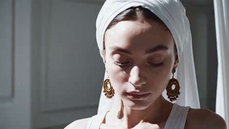 woman in white hijab and gold jewelry