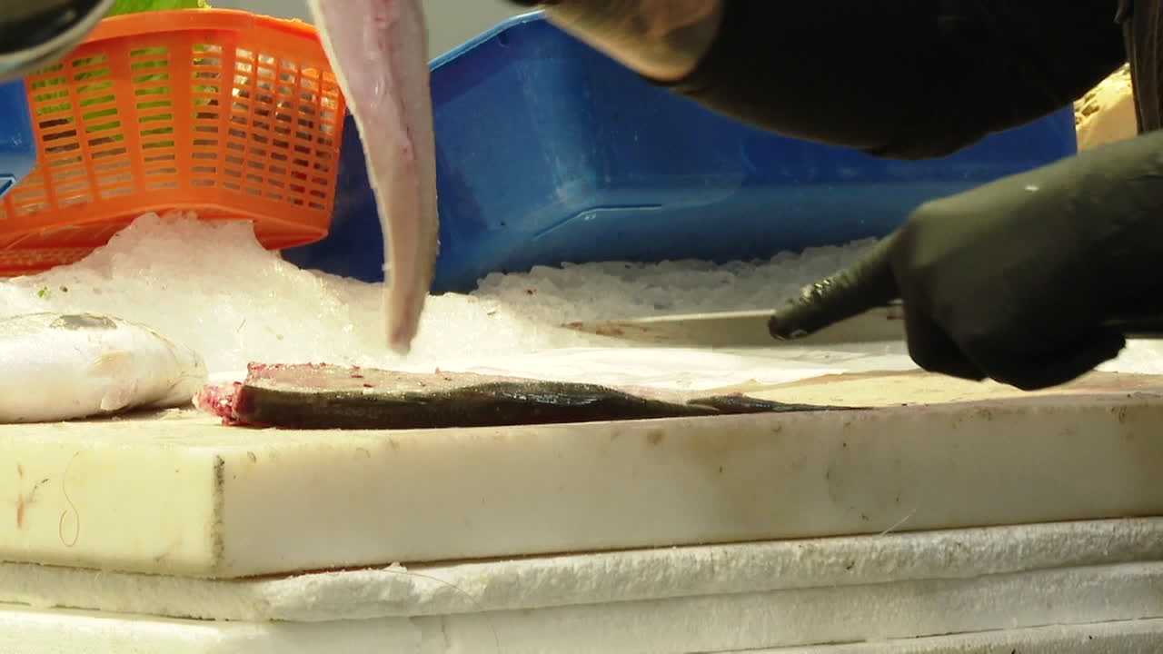 Fishmonger cutting fresh fish at a market