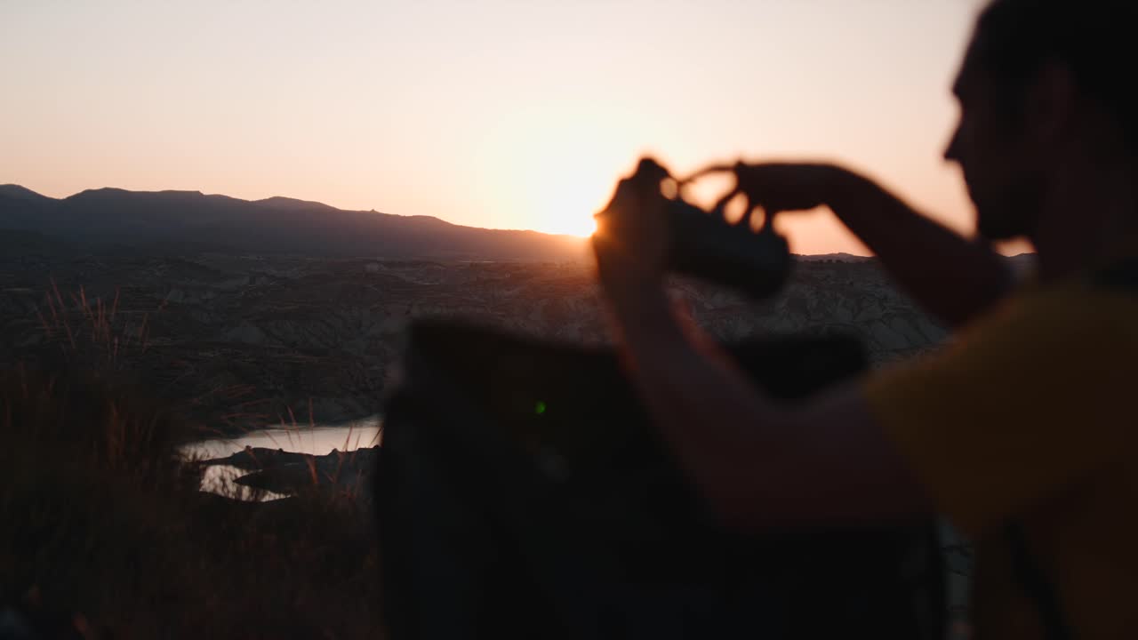 Amanecer sobre las montañas con una persona disfrutando de las vistas