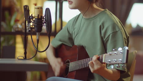 asian woman recording song at home studio