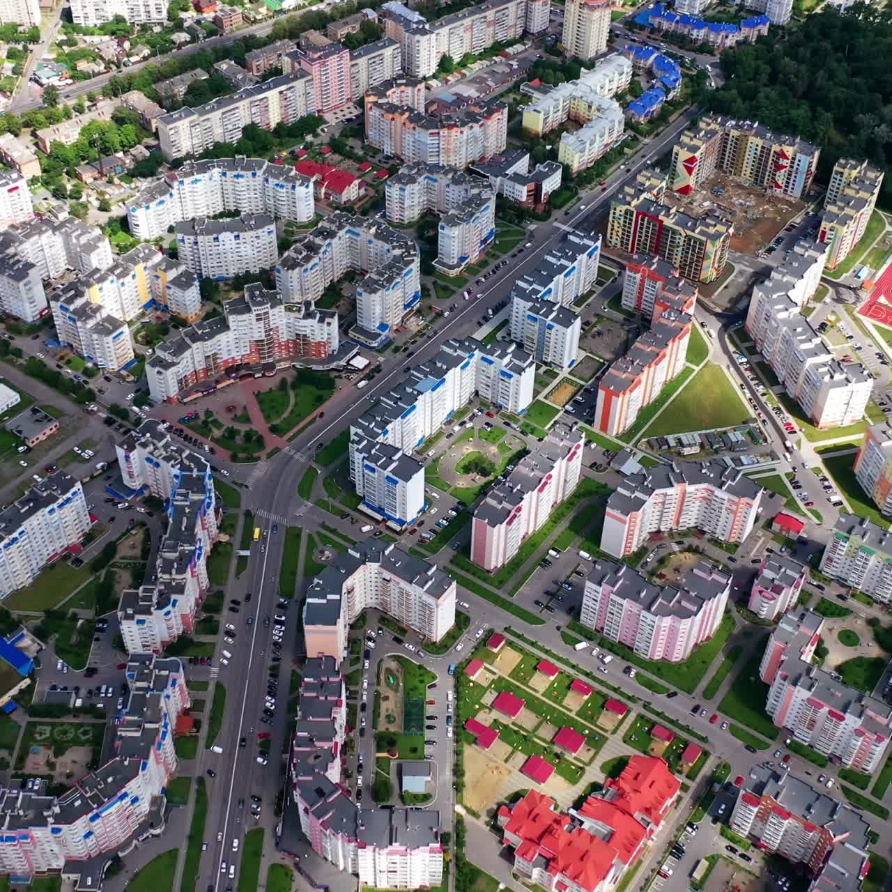 Urban background. Modern city with skyscrapers and traffic with cars. View from above on high-rise residential buildings. Aerial view.