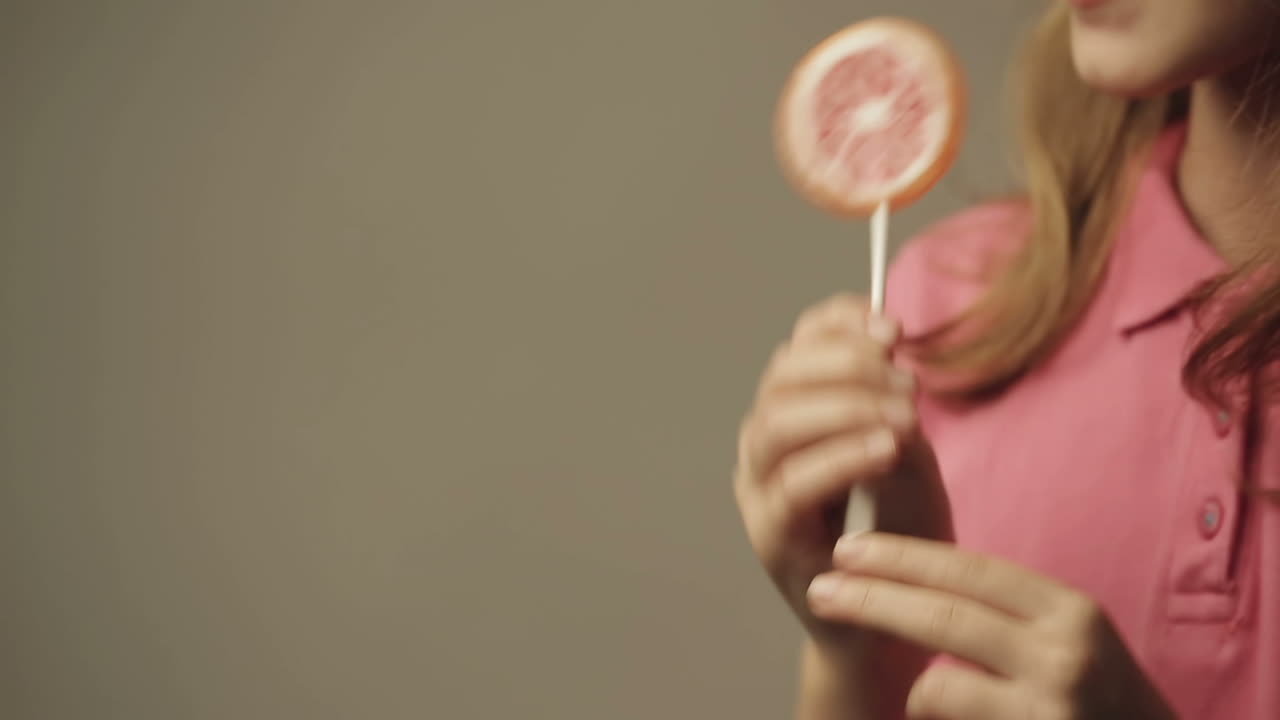 Happy smiling cute little girl eating candy