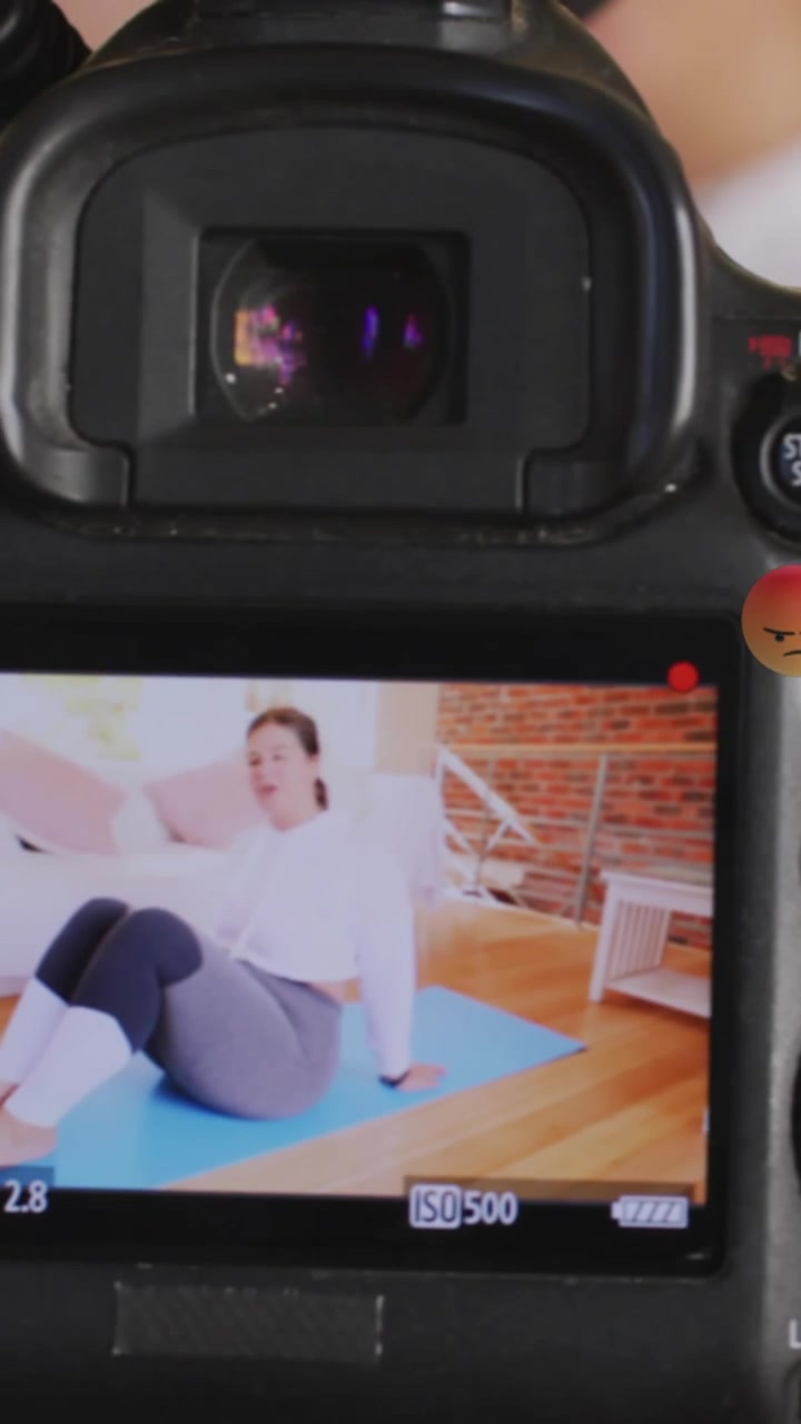 Animazione di emoji su un visore della fotocamera con una vlogger di fitness che si allena a casa