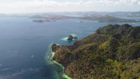 cinematic aerial footage of the palawan cliffs at bright daylight with beaches and boats in view, drone, philippines, asia