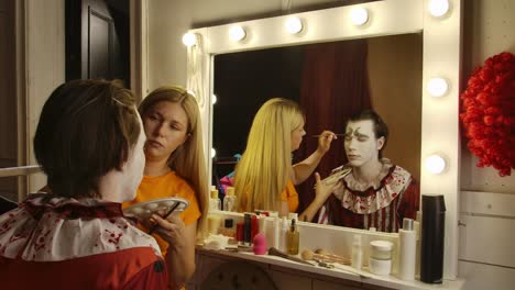 makeup artist applying clown makeup for a halloween event