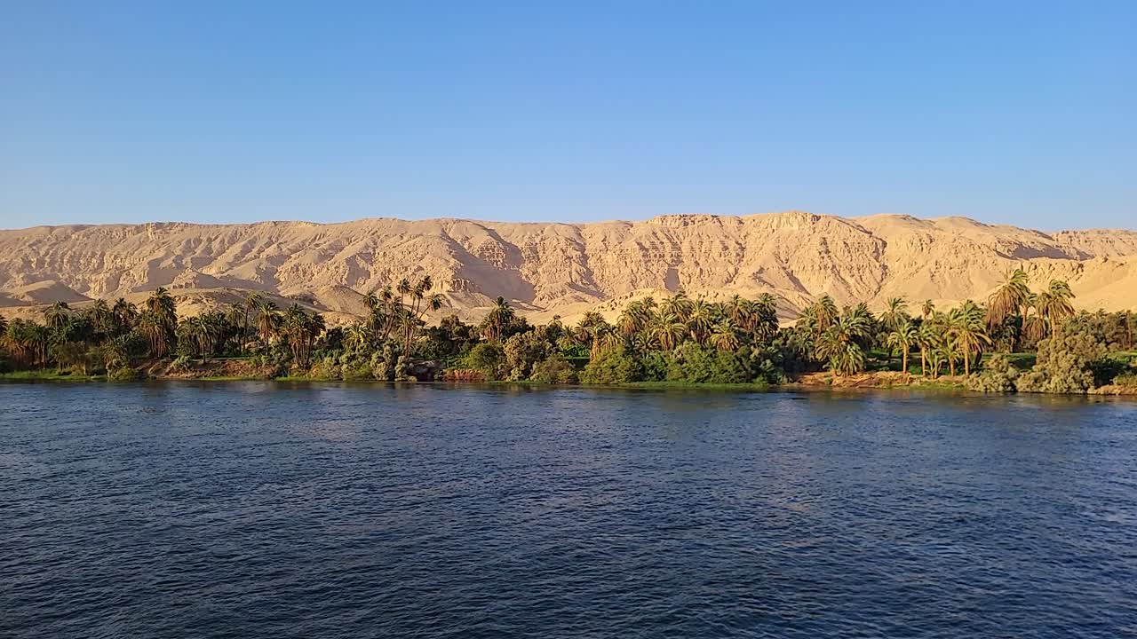 orillas del nilo con vegetación y montañas desérticas en el fondo