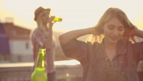 A-young-female-moves-in-a-dance-with-her-friends-on-the-roof.-She-develops-hair-with-her-hands-and-moves-her-body-beautifully.