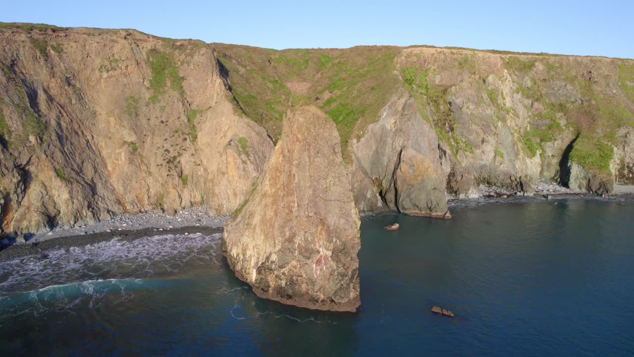 drone dando vueltas en el mar en tankardstown copper coast waterford irlanda con el antiguo sitio minero en la colina