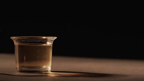 video of lit alcohol in glass with yellow fire flames and copy space on black background