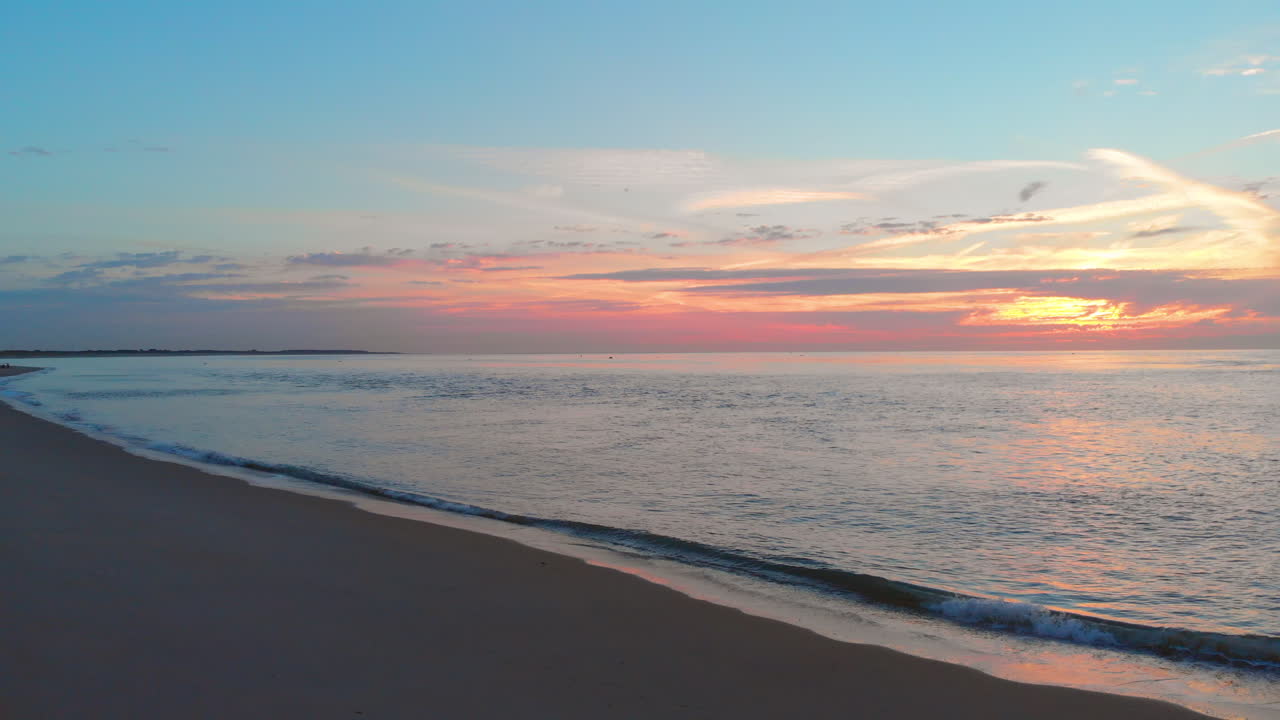 una marea baja tranquila en la playa cerca de la barrera de marejada en el suroeste de los países bajos, durante la puesta de sol