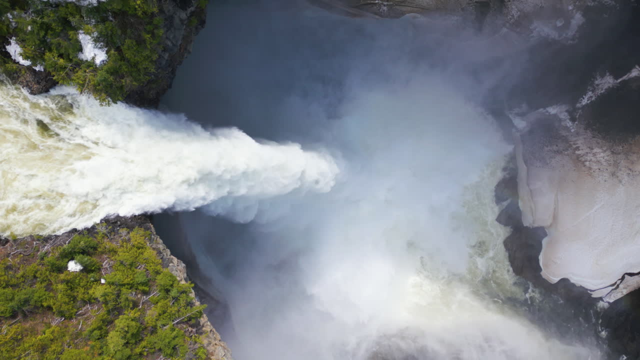 캐나다 헬름켄 폭포 위 를 회전 하는 공중 의 새 눈