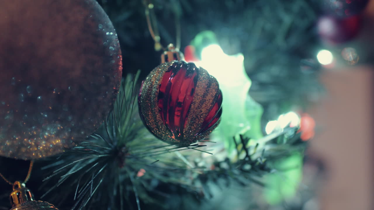 Glimmerkugler der hænger på juletræet med oplyste festlige lys om natten.